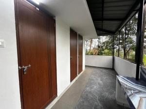 an empty hallway with wooden doors and windows at Cozstel in Kozhikode