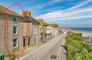 a row of houses on a street next to the ocean at Minster Panorama & Minster Vista - - UNBROKEN BEACHFRONT VIEWS - - TWO STUNNING GEORGIAN HOUSES THAT CONNECT - - PRIVATE PARKING - - Beautifully Refurbished MARCH 2026 in St Ives