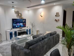 a living room with couches and a flat screen tv at Résidence ABOMO'S in Kribi