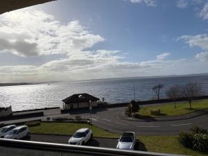 a group of cars parked next to a body of water at View of the Isles 2 in Largs