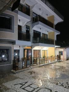a large white building with a balcony at night at Résidence ABOMO'S in Kribi
