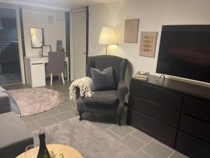 ein Wohnzimmer mit einem Sessel und einem Flachbildfernseher in der Unterkunft Harmonie in Landskrona