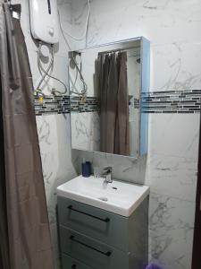 a bathroom with a sink and a mirror at Résidence ABOMO'S in Kribi +51 photos