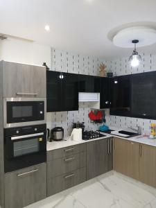 a kitchen with wooden cabinets and a stove top oven at Résidence ABOMO'S in Kribi