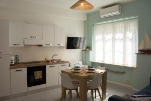 a kitchen with a table and chairs in a kitchen at Velaria Apartment in Termoli