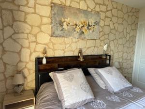 a bed with two pillows and a painting on the wall at Les Crins Du Bonheur Chambre et Table Hôtes Belle Vue in Fraisse