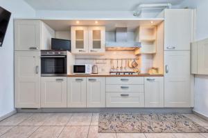 a large kitchen with white cabinets and appliances at Venice Vacation in Marghera