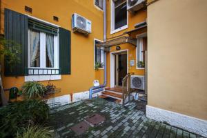 an entrance to a yellow building with a door and stairs at Venice Vacation in Marghera