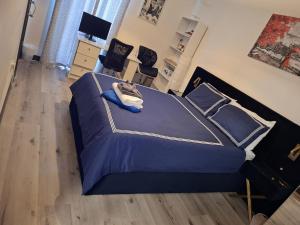 a bedroom with a bed with blue sheets and pillows at Host-Free Ensuite Double Bed by Heathrow in Feltham