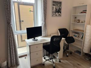 an office with a desk with a computer and two chairs at Host-Free Ensuite Double Bed by Heathrow in Feltham