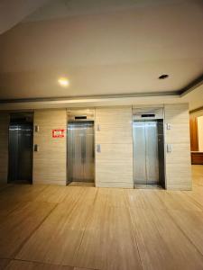 a row of elevators in a room with wooden floors at Kishori Ji Homes in Chhatikara