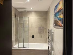 a bathroom with a shower with a bath tub at Host-Free Ensuite Double Bed by Heathrow in Feltham +15 photos