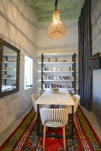 a dining room with a table and chairs and a mirror at Dar Antonia in Sousse