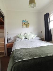 a bedroom with a bed with white sheets and pillows at The Warren Chalet in Cromer