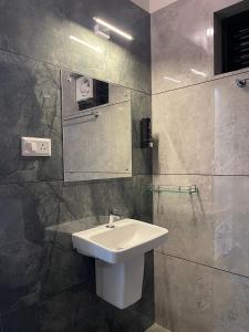 a bathroom with a sink and a mirror at Neev holiday homes in Vythiri +14 photos