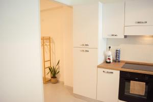 a kitchen with white cabinets and a black oven at Velaria Apartment in Termoli