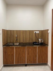 a kitchen with wooden cabinets and a counter top at Neev holiday homes in Vythiri