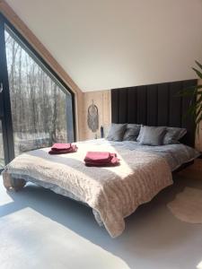 a bedroom with a large bed with two towels on it at Chill ChaTka Osowiec Las&SPA pod Warszawą in Osowiec
