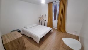 a bedroom with a bed and a table and a window at 8C - L'Urban in Saint-Rambert-dʼAlbon