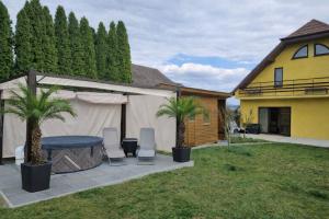 a backyard with a table and two palm trees at Apartmány Lužianky in Nitra