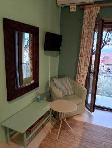 a living room with a couch and a table and a mirror at iliolithos rooms in Kardamyli