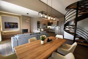 a living room with a wooden table and a staircase at Thea Hill in Kritharia