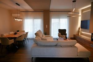 a living room with a couch and a dining table at Thea Hill in Kritharia