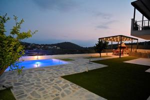 a backyard with a swimming pool at night at Thea Hill in Kritharia