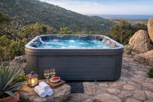 a jacuzzi tub with wine glasses and candles at Villa Esmerea Portocervo con Piscina privata ,Jacuzi e Sauna in Porto Cervo