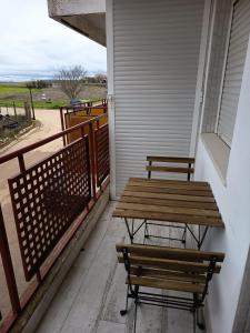 two benches and a wooden table on a porch at Apartamento Buendia in Buendía