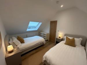 two beds in a small room with a window at Westwinds View in Ludlow