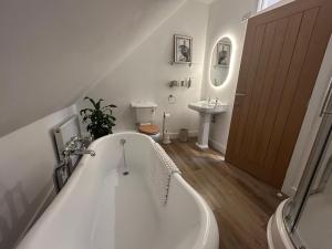 a white bath tub in a bathroom with a sink at Westwinds View in Ludlow +37 photos