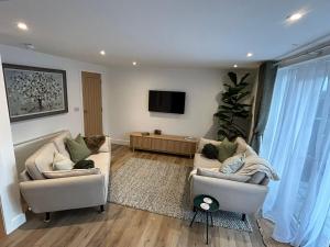 a living room with two couches and a flat screen tv at Westwinds View in Ludlow