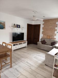 a living room with a couch and a flat screen tv at Apartamento Buendia in Buendía
