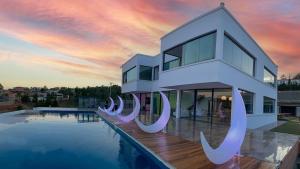 a house with a swimming pool in front of a sunset at Ricefield Valley in Mandrangobato