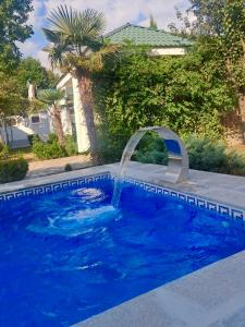a pool with a water fountain in a yard at Qebele hot pool in Gabala +37 photos