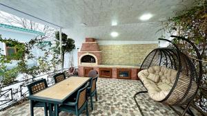 a patio with a table and chairs and a fireplace at Qebele hot pool in Gabala