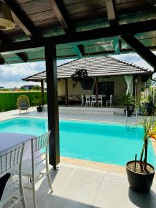 a swimming pool with a table and a house at Vikendoria Pool House & Events in Bački Jarak