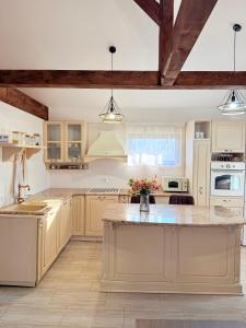 a kitchen with white cabinets and a large island at Vikendoria Pool House & Events in Bački Jarak
