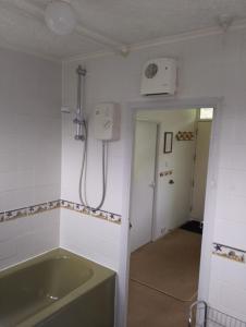 a bathroom with a tub and a shower at The Warren Chalet in Cromer