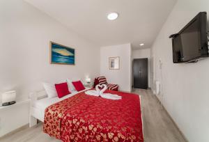 ein Schlafzimmer mit einem Bett mit einer roten Decke in der Unterkunft Hotel Azzurro in Herceg-Novi