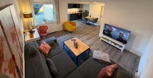 a living room with a couch and a flat screen tv at Miras Guesthouse Ferienwohnung in Lengerich
