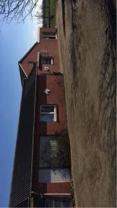 a tall red building next to a wall at Ferienhaus Arlewatt in Arlewatt