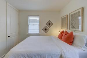 a bedroom with a large white bed with orange pillows at Gated Cottage Community! Ideal Midtown Spot in Memphis