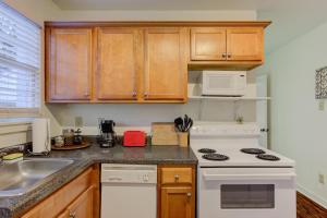 a kitchen with wooden cabinets and a white stove top oven at Gated Cottage Community! Ideal Midtown Spot in Memphis +19 photos