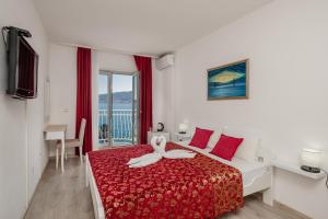 ein Schlafzimmer mit einem Bett mit roter Tagesdecke in der Unterkunft Hotel Azzurro in Herceg-Novi