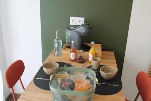 a table with cups and bowls on top of it at chez laetitia proche du puy in La Flocellière