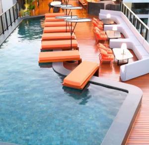 a swimming pool with chairs and tables on a building at Cabo Branco Flat Amsterdam in João Pessoa
