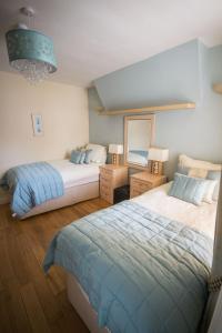 a bedroom with two beds and a chandelier at Atlantic Heights Guest House in St Ives