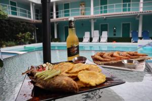 a table with a plate of food and a bottle of beer at Pacific Coast Hotel in Playa Bonita Village